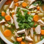 Delicious bowl of chicken and vegetable soup, featuring tender chicken pieces, colorful vegetables, and fresh herbs, served in a rustic setting